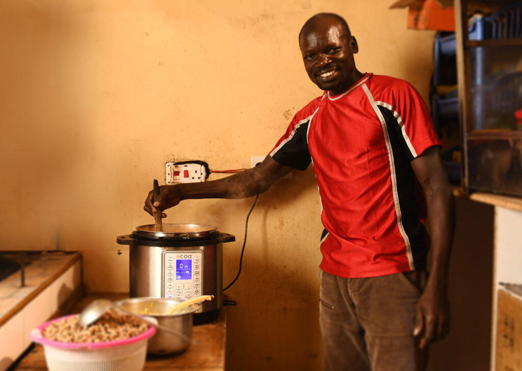 Photo: A man in Kenya cooking food on an electric pressure cooker – BURN