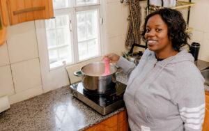 Photo: A woman in Kenya cooking food on an electric induction cooker – BURN