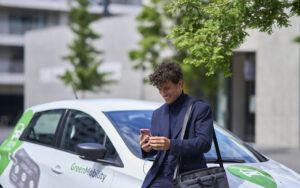 A user of GreenMobility car checking his phone