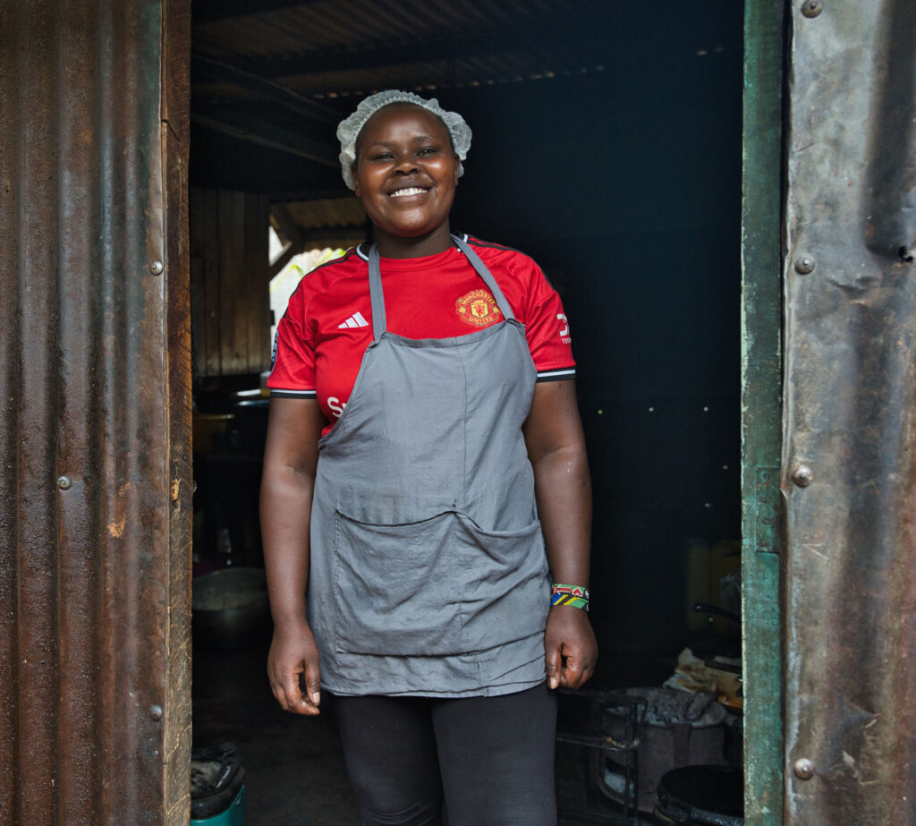 Photo: Female customer in Kenya cooking food on a sustainable, biomass cookstove – Jason Mulikita for MCFA/Nefco